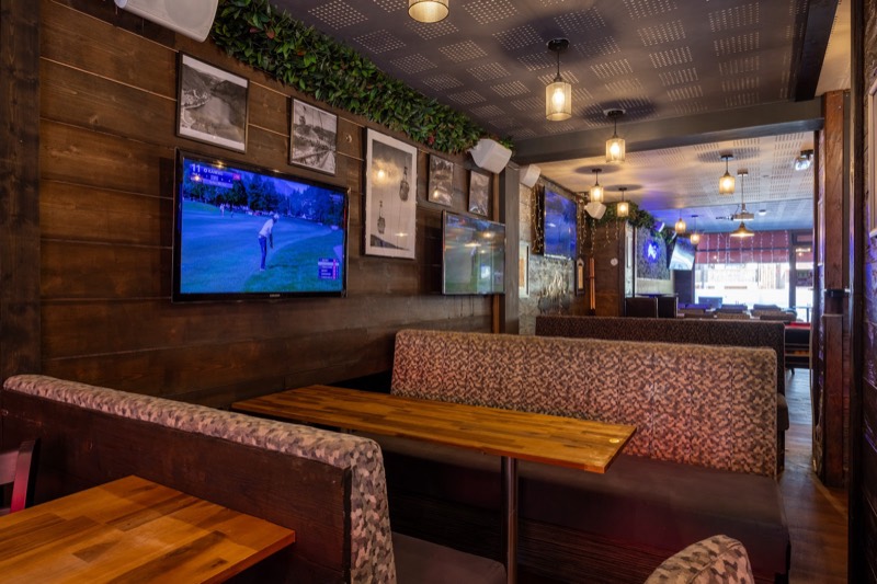 Booths and big screen in the Rhodos bar