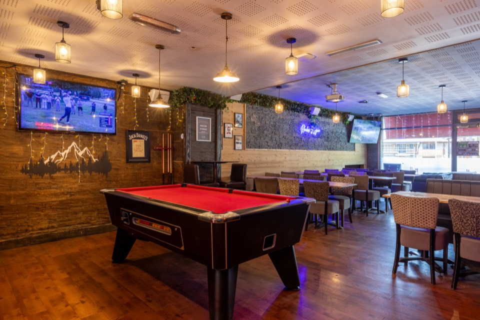 Pool table and booths in the Rhodos bar